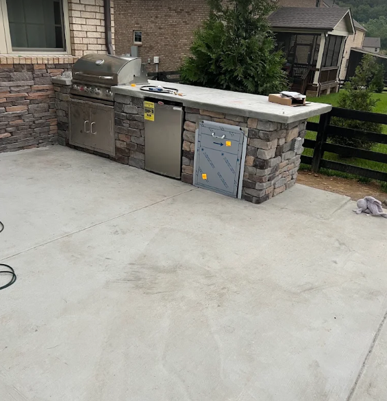 Stone outdoor kitchen with grill and refrigerator